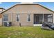 A spacious backyard with green grass and a view of the home's rear exterior, including a screen patio at 8620 Sandy Plains Dr, Riverview, FL 33578