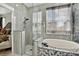 Bright bathroom featuring a glass shower, soaking tub, and modern fixtures at 8620 Sandy Plains Dr, Riverview, FL 33578