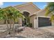 Charming home features stone accents, lush landscaping, and a quaint bench, creating an inviting entrance at 8620 Sandy Plains Dr, Riverview, FL 33578
