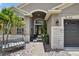 Landscaped yard features an ornate bench, potted plants, and decorative rocks that leads up to the home's inviting entrance at 8620 Sandy Plains Dr, Riverview, FL 33578