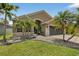 Landscaped yard features palm trees and decorative rocks, leading up to this home's inviting front entrance at 8620 Sandy Plains Dr, Riverview, FL 33578