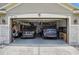 Clean, two-car garage with epoxy floor, overhead storage and two late model SUVs parked inside at 8620 Sandy Plains Dr, Riverview, FL 33578