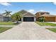 Suburban home featuring a wide driveway, well-manicured lawn and tropical landscaping at 8620 Sandy Plains Dr, Riverview, FL 33578