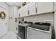 This laundry room features upper cabinets, a sink, a washer, and a dryer at 8620 Sandy Plains Dr, Riverview, FL 33578