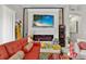 Cozy living room featuring a modern fireplace, red sofa, and natural light at 8620 Sandy Plains Dr, Riverview, FL 33578