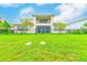 Expansive backyard featuring lush green grass, modern design, and a black fence at 8717 Sanders Tree Loop, Wesley Chapel, FL 33545
