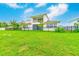 Expansive backyard featuring lush green grass, modern design, and partial fence views at 8717 Sanders Tree Loop, Wesley Chapel, FL 33545