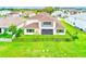 A home's fenced backyard has a lush lawn and a patio with a balcony above at 8717 Sanders Tree Loop, Wesley Chapel, FL 33545