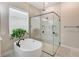 The bathroom features a soaking tub, glass shower and a decorative plant at 8717 Sanders Tree Loop, Wesley Chapel, FL 33545