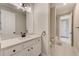 Bathroom featuring a white vanity with a dark faucet and a large framed mirror at 8717 Sanders Tree Loop, Wesley Chapel, FL 33545