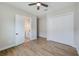 Bedroom with hardwood floors, a ceiling fan, closet, and access to a bathroom at 8717 Sanders Tree Loop, Wesley Chapel, FL 33545