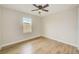 Bedroom featuring light wood floors, a ceiling fan, and a window at 8717 Sanders Tree Loop, Wesley Chapel, FL 33545
