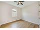 Bright bedroom features hardwood floors, ceiling fan, and natural light at 8717 Sanders Tree Loop, Wesley Chapel, FL 33545