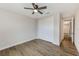 This is a neutral bedroom with a ceiling fan, closet, and lovely wood-look floors at 8717 Sanders Tree Loop, Wesley Chapel, FL 33545