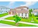Aerial view of a well-maintained single-Gathering home, featuring a lush green lawn and neutral color palette at 8717 Sanders Tree Loop, Wesley Chapel, FL 33545