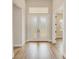 Elegant home foyer featuring decorative glass doors, light walls, and hardwood flooring throughout at 8717 Sanders Tree Loop, Wesley Chapel, FL 33545