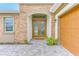 Beautiful home entrance with brick facade, arched doorway, and well-maintained landscaping at 8717 Sanders Tree Loop, Wesley Chapel, FL 33545