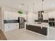Gorgeous gourmet kitchen with white cabinets, stainless steel appliances, and a central island at 8717 Sanders Tree Loop, Wesley Chapel, FL 33545