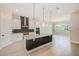 Open-concept kitchen with large island, stainless steel range hood, and modern lighting at 8717 Sanders Tree Loop, Wesley Chapel, FL 33545