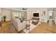 Comfortable living room with stylish furnishings, hardwood floors, a ceiling fan, and abundant natural light at 8717 Sanders Tree Loop, Wesley Chapel, FL 33545