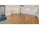 Large living area with wood floors, a ceiling fan, and staircase, filled with natural light at 8717 Sanders Tree Loop, Wesley Chapel, FL 33545
