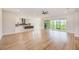 Open-concept living space with luxury vinyl plank flooring and sliding glass doors to the backyard at 8717 Sanders Tree Loop, Wesley Chapel, FL 33545