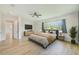 Bedroom featuring a ceiling fan, large window, and ensuite bathroom at 8717 Sanders Tree Loop, Wesley Chapel, FL 33545