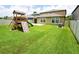 Wide backyard with a green lawn, patio, and wooden playset at 9650 Sage Creek Dr, Ruskin, FL 33573