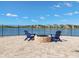 Lakefront patio with brick fire pit and blue Adirondack chairs at 9650 Sage Creek Dr, Ruskin, FL 33573