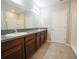 Modern bathroom with a double vanity with granite countertops, tiled floors and doors at 9650 Sage Creek Dr, Ruskin, FL 33573