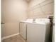Functional laundry room with washer, dryer, and wire shelving at 9650 Sage Creek Dr, Ruskin, FL 33573