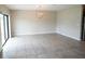 Bright living room featuring ceramic tile floors, modern light fixture, and sliding glass doors at 9650 Sage Creek Dr, Ruskin, FL 33573
