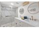 Bathroom featuring a double sink vanity, walk-in shower, and decorative mirrors at 10280 Gulf Blvd # 12, St Petersburg, FL 33706