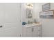 Bathroom featuring a single sink vanity with framed artwork and decorative light fixture at 10280 Gulf Blvd # 12, St Petersburg, FL 33706