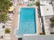 Overhead view of community pool with lounge chairs, tables, and shade, surrounded by tropical landscaping at 10280 Gulf Blvd # 12, St Petersburg, FL 33706