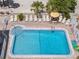 Relax by the pool with lounge chairs, tables, and shade, surrounded by well-maintained grounds at 10280 Gulf Blvd # 12, St Petersburg, FL 33706