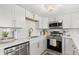 Contemporary kitchen showcasing stainless steel appliances, stylish backsplash, and ample counter space at 10280 Gulf Blvd # 12, St Petersburg, FL 33706