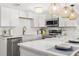 Modern kitchen featuring stainless steel appliances, elegant pendant lights, and spacious countertops at 10280 Gulf Blvd # 12, St Petersburg, FL 33706