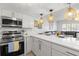 Open concept kitchen featuring stainless steel appliances, quartz countertops, and decorative lighting at 10280 Gulf Blvd # 12, St Petersburg, FL 33706
