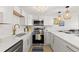 Bright kitchen with white cabinets, stainless steel appliances, and modern lighting fixtures at 10280 Gulf Blvd # 12, St Petersburg, FL 33706