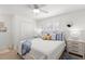 Bedroom featuring white walls, neutral bedding, ceiling fan, and double door closet at 10280 Gulf Blvd # 12, St Petersburg, FL 33706