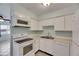 Kitchen with white appliances and cabinets, and an adjacent room with lots of sunlight at 1049 Apollo Beach Blvd # D, Apollo Beach, FL 33572