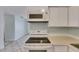 Close up shot of an electric range and a built in microwave in the kitchen at 1049 Apollo Beach Blvd # D, Apollo Beach, FL 33572