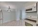 Kitchen with white appliances that leads into a small dining area with a stylish chandelier at 1049 Apollo Beach Blvd # D, Apollo Beach, FL 33572