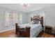 Comfortable bedroom with hardwood floors, soft blue walls, large window, and a decorative bedframe at 11451 82Nd Ave, Seminole, FL 33772