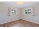 Bedroom featuring wood-look flooring and two windows at 11451 82Nd Ave, Seminole, FL 33772