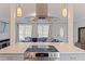 Modern kitchen island with cooktop and range hood, offering a view to the living room with comfortable seating at 11451 82Nd Ave, Seminole, FL 33772