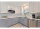 Well-lit kitchen with stainless steel appliances, white upper cabinets, and gray lower cabinets at 11451 82Nd Ave, Seminole, FL 33772