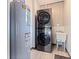Laundry room featuring a modern stacked washer and dryer unit next to the utility sink and water heater at 11451 82Nd Ave, Seminole, FL 33772
