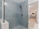 Walk-in shower with blue tiling, pebble accents, and a modern showerhead at 11451 82Nd Ave, Seminole, FL 33772
